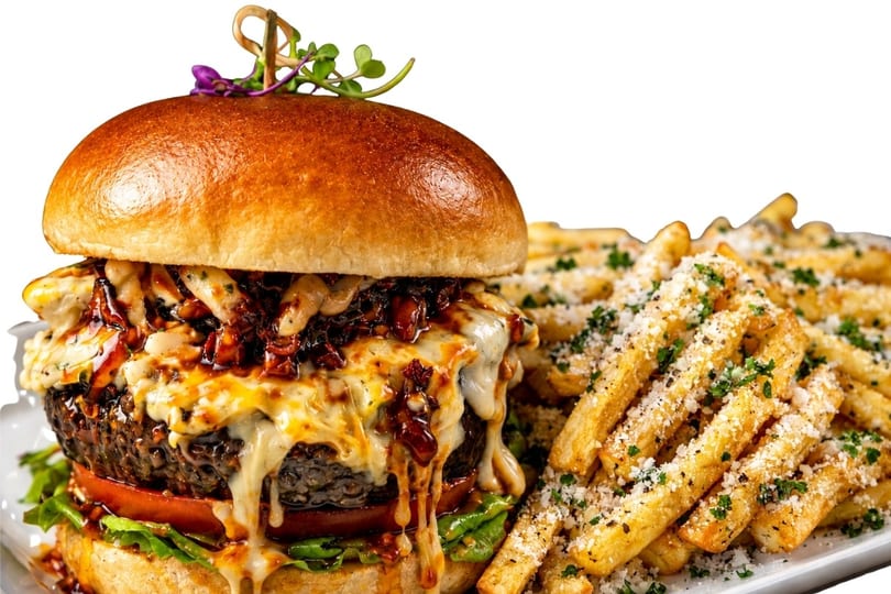 Gourmet burger with melted cheese, bacon, and a side of parmesan truffle fries.